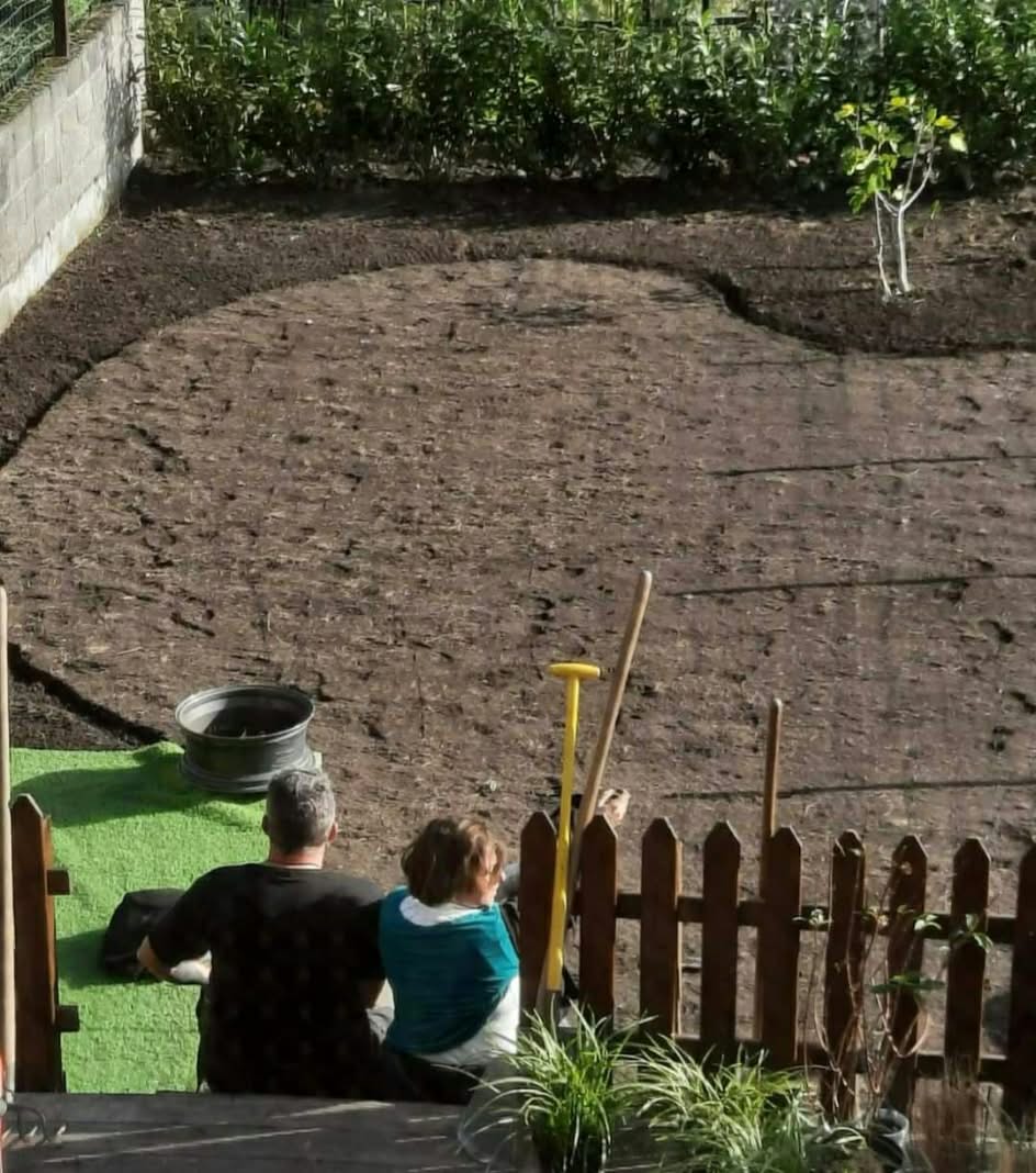 Pascal et Nathalie Riga contemplant un jardin en cours de création, terre préparée et bordures dessinées