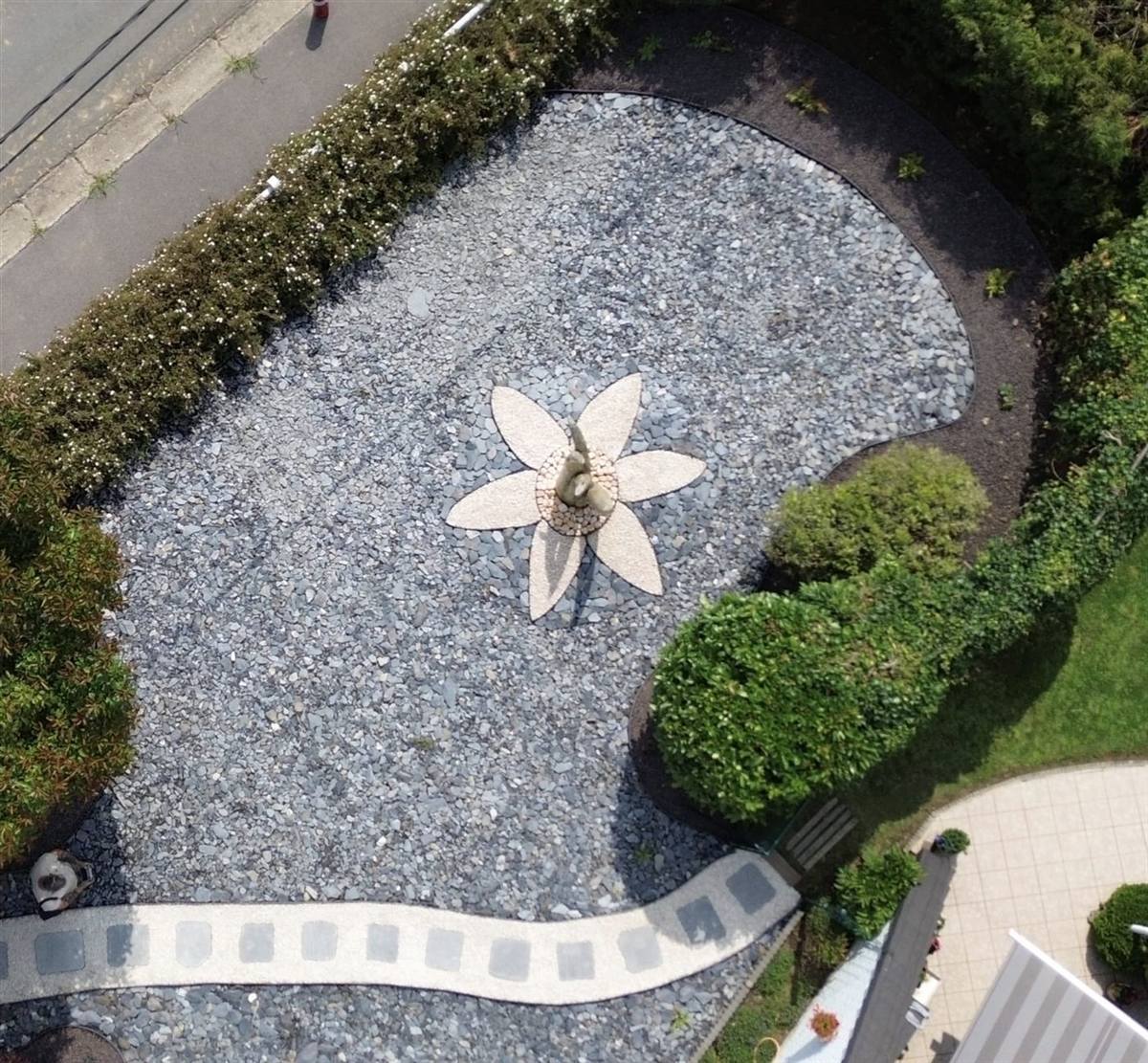 Composition minérale en forme de fleur, ardoise et galets, réalisée par L'Harmonie du Jardin