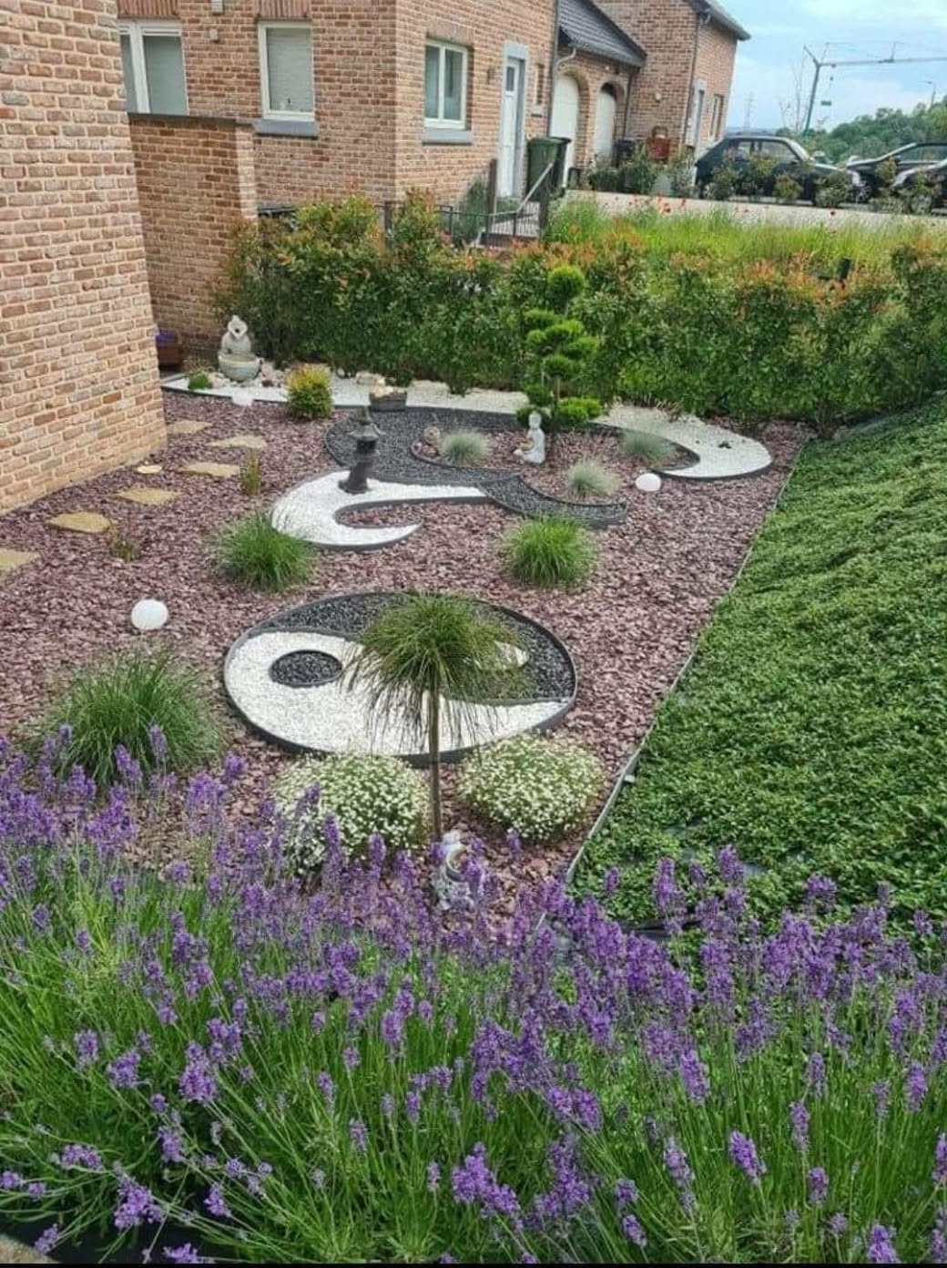 Jardin de ville avec compositions yin-yang en pierre sombre et galets blancs, gravier rosé et lavandes