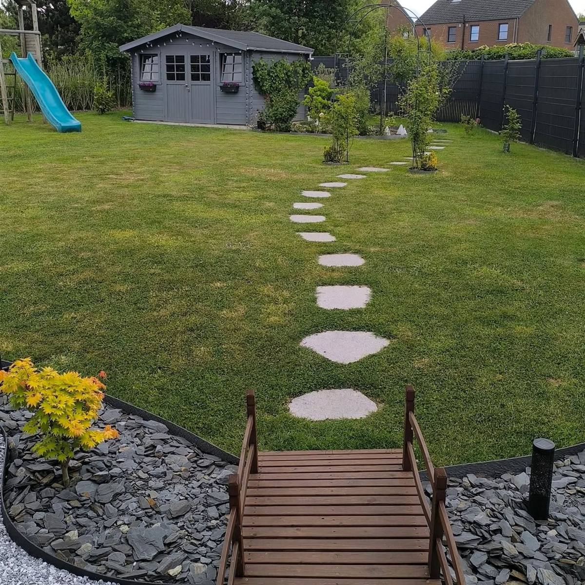Pont en bois et pas japonais reliant les espaces du jardin